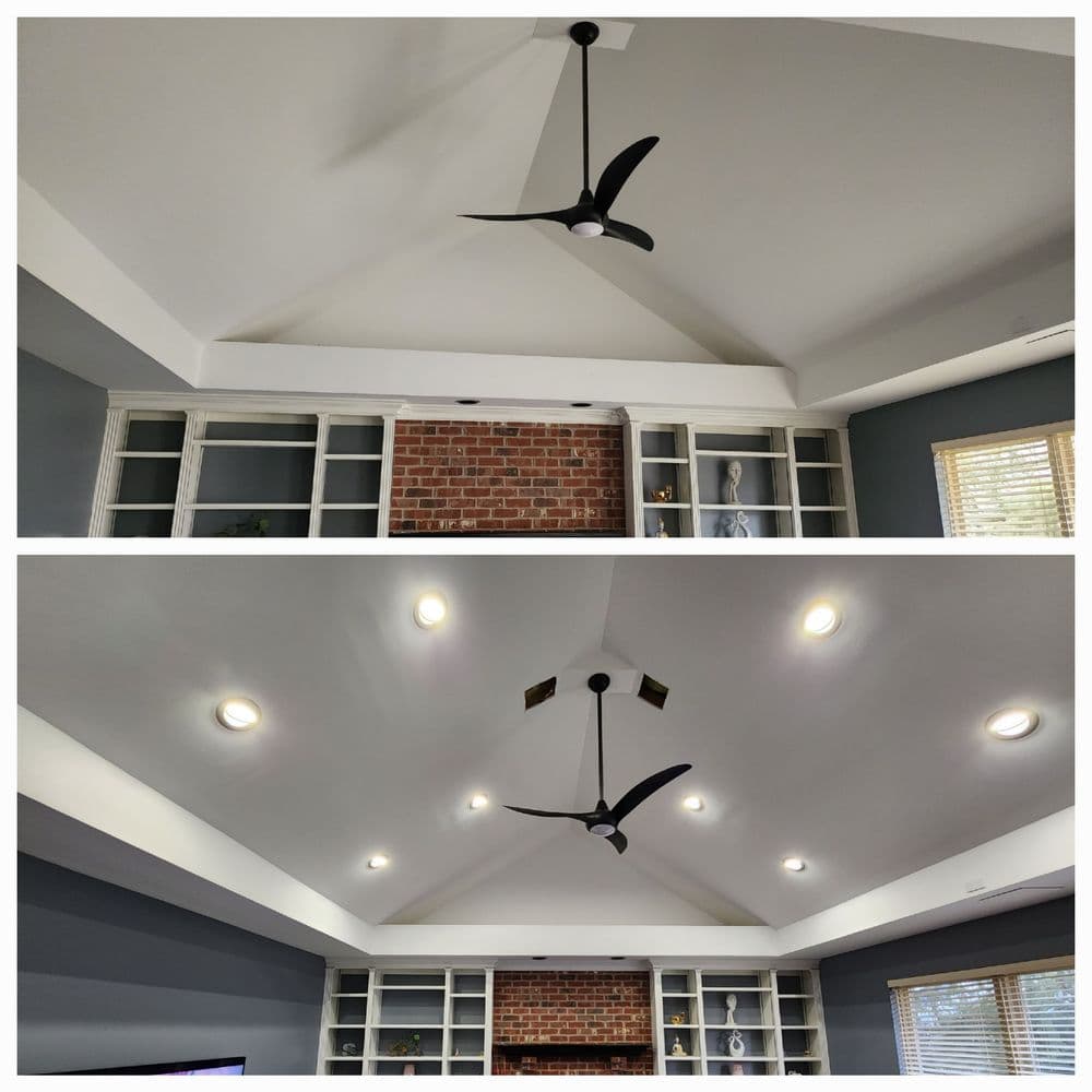 Modern living room ceiling with black fan and recessed lighting, showcasing a stylish design.